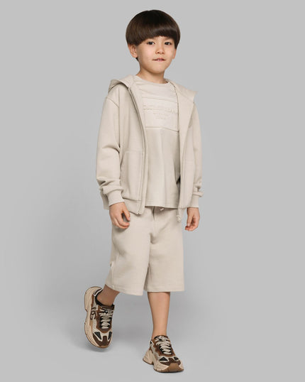 boy wearing clothing from kids atelier posing in desert promoting end of season sale 